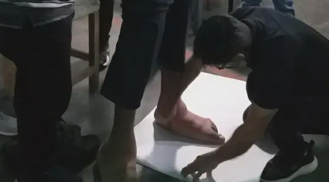 Joven venezolano con los pies más grandes del mundo espera por la elaboración de zapatos