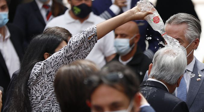 Una mujer vacía una botella de agua sobre la cabeza del presidente chileno (Video)