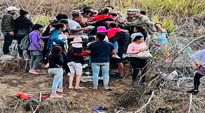 Migrantes derriban el cerco de púas en la frontera de México-EEUU