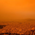 Cielo de Atenas teñido de naranja por las nubes de polvo del Sahara