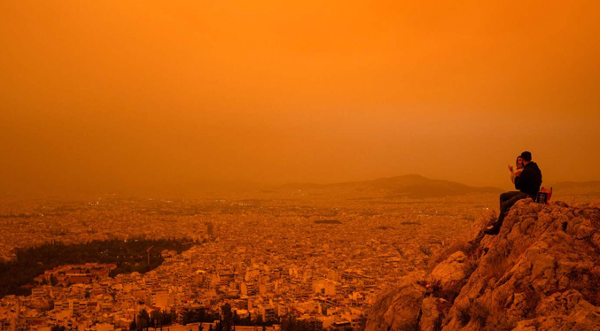 Cielo de Atenas teñido de naranja por las nubes de polvo del Sahara