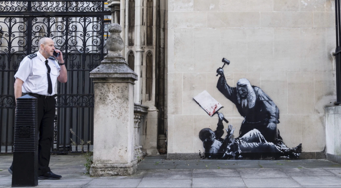 Nuevo mural de Banksy muestra a un juez golpeando a un manifestante, será retirado